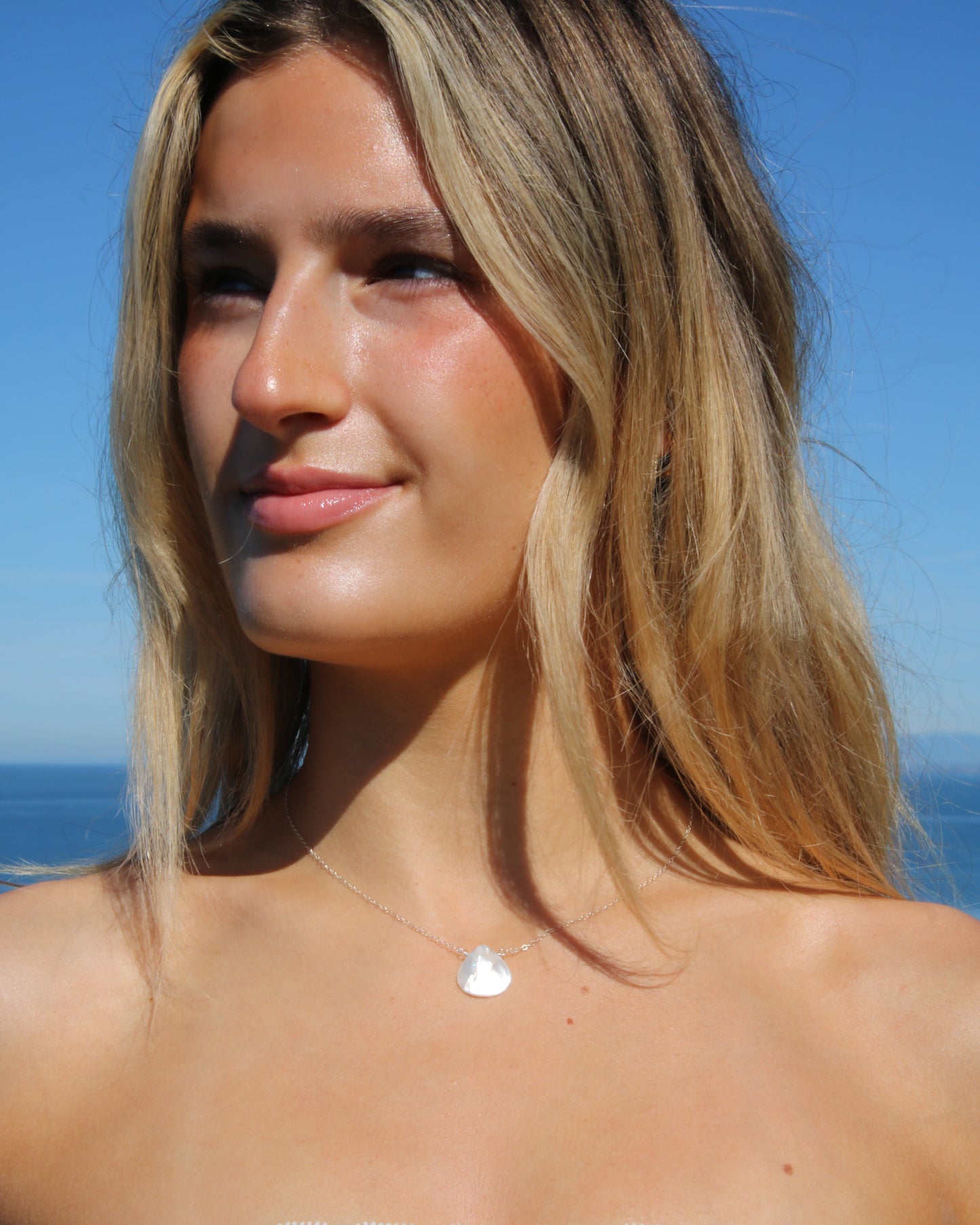 Woman with a white top against a blue sky